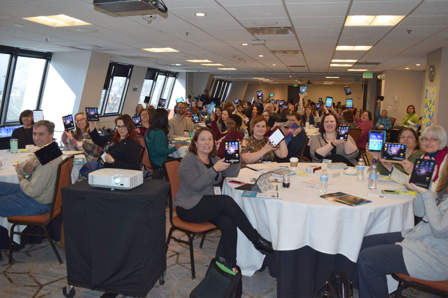 Librarians holding up tablets at NASA@ My Library Workshop