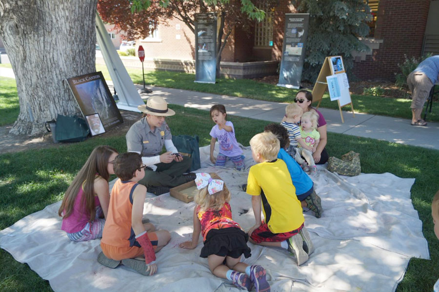Park Ranger demonstrating eclipse concept to children