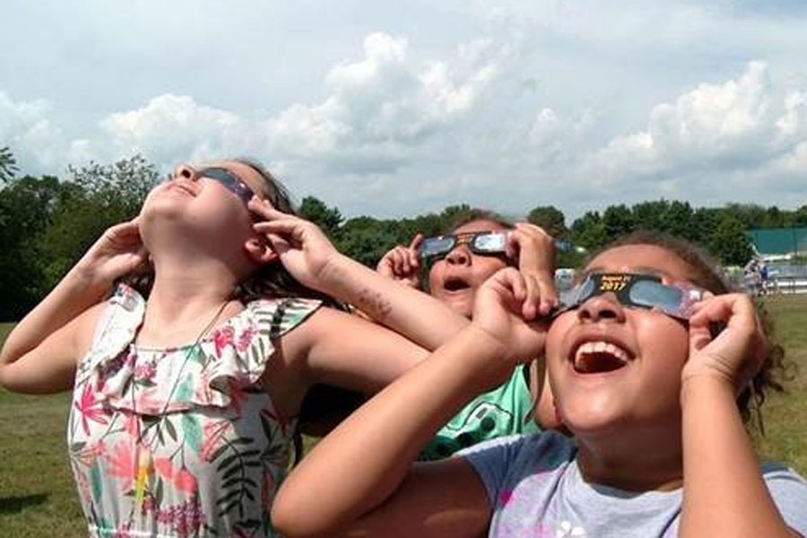 Girls using eclipse glasses to view 2017 solar eclipse