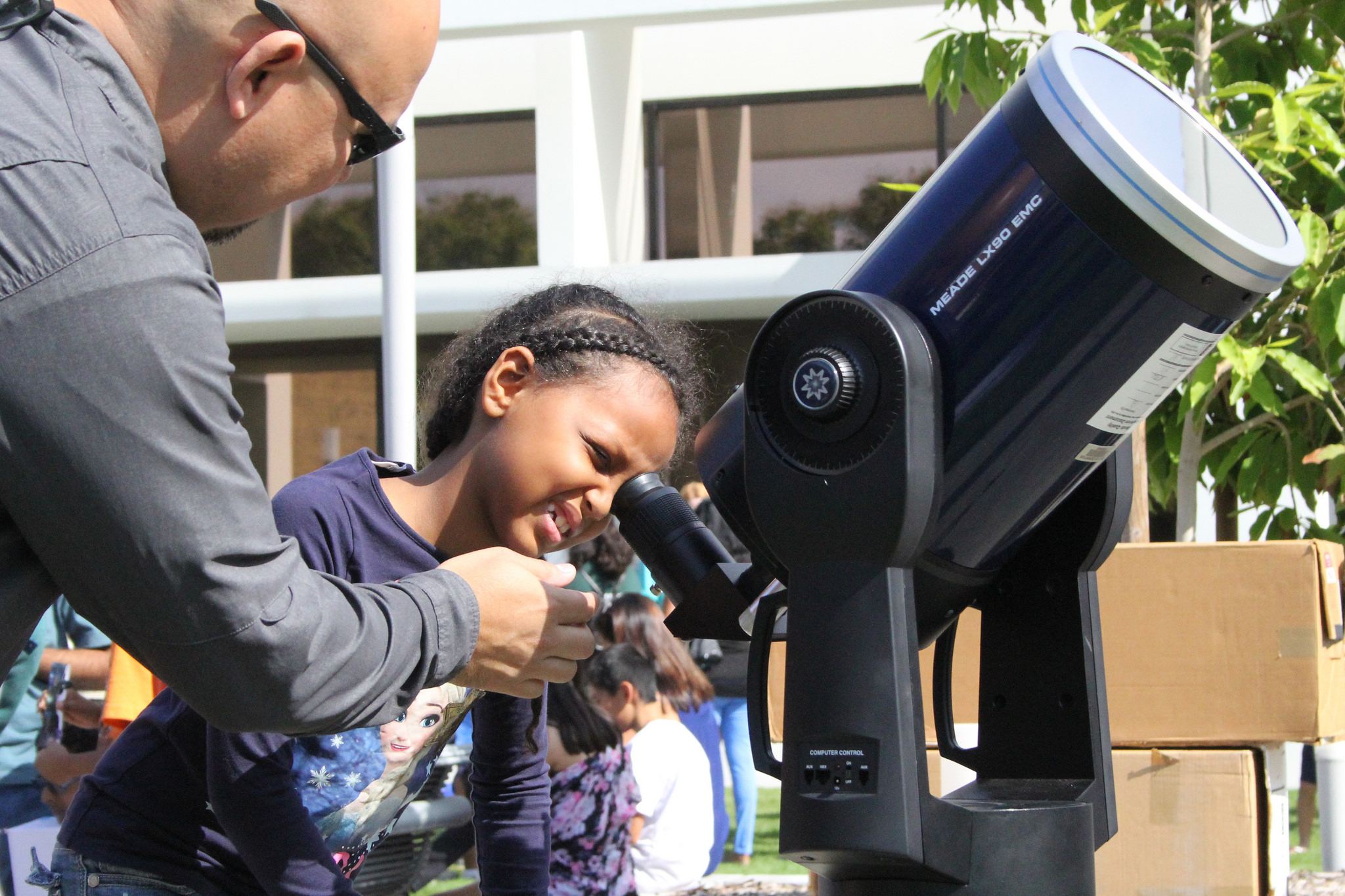 Child looking through a solar scope 