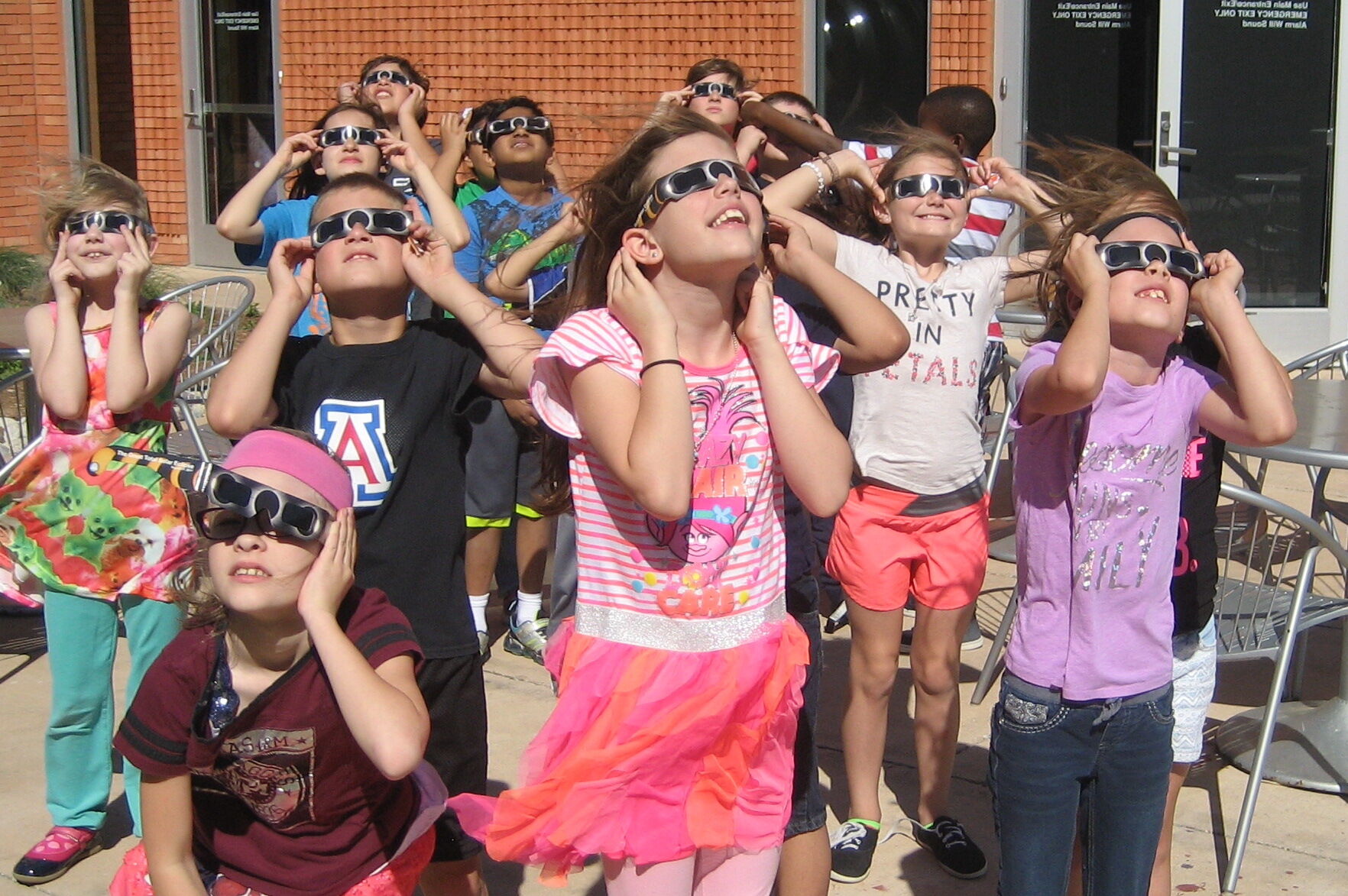 Children with eclipse glasses looking at Sun