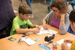 A family working on the robot paper circuit challenge.