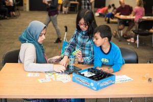 A family working on Gravity Maze challenge cards.