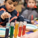 Kids mix different liquids with milk to see different chemical reactions.